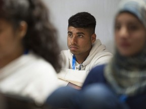 Recent immigrant and refugee children, ages 14 through 18, listen to a presentation from RCMP at the Surrey school district Welcome Centre during a summer session.