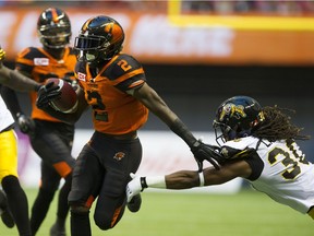 Chris Rainey eludes Hamilton Tiger-cats Jay Langa to run the ball into the end zone in a regular season CFL football game at BC Place, Vancouver, August 13 2016.