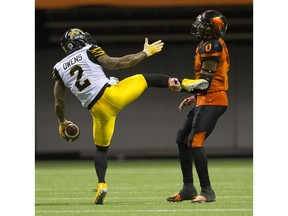 Hamilton Tiger-Cats Chad Owens gestures to BC Lions Loucheiz Purifoy as he holds Owen's foot after Owens completed a pass in a regular season CFL football game at BC Place, Vancouver, August 13 2016.