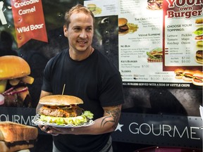 Brian Jones of Gourmet Burgers holds a 10-pound Hercules Burger, which takes an hour to cook and feeds 15 people.
