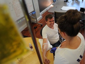 Joel Welch, a media buyer with Mainland Digital, gets a vitamin boost via IV from Dr. Erika Kubanek at the company's offices in Gastown.