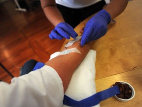 Carly Giroux, a marketing assistant at the Social-Media startup Joiiin, gets a vitamin boost via IV from Dr. Erika Kubanek at the comapny's offices in Gastown.