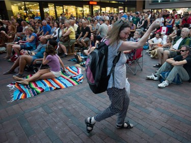 A woman dances as people gather for a viewing party for the final stop in Kingston, Ont., of a 10-city national concert tour by The Tragically Hip, in Vancouver, B.C., on Saturday August 20, 2016. Lead singer Gord Downie announced earlier this year that he was diagnosed with an incurable form of brain cancer.