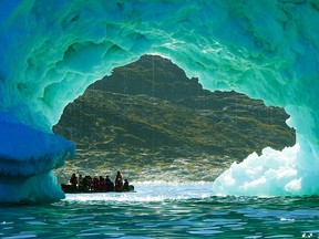 A Zodiac and its passengers from the One Ocean’s Expedition ship, Akademik Sergey Vavilov, are framed by an iceberg near Ilulissat’s harbour on the west coast of Greenland.