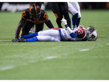 Montreal Alouettes' quarterback Rakeem Cato, right, lies on the ground after being sacked by B.C. Lions' Alex Bazzie during the second half of a CFL football game in Vancouver, B.C., on Friday September 9, 2016.