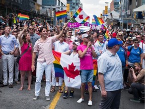 Prime Minister Justin Trudeau (middle, holding flag) participates at the annual Pride Festival parade on July 3 in Toronto.