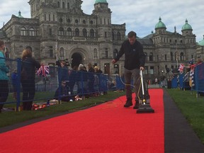 B.C. legislature staff vacuuming the red carpet as die hard royal watchers gather for the arrival of the Duke and Duchess of Cambridge in Victoria, B.C. Saturday. For 0925 royal colour [PNG Merlin Archive]