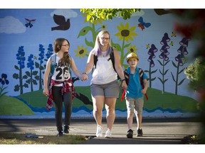 Jamie Garrett picks up her daughter Morgan (left) and son Fynn from after-school care at Graham Bruce elementary school in east Vancouver earlier this month. ‘I know people raising kids in basement suites,’ Garrett says. ‘It's not great living. Because child-care fees have to go up every year, people can't keep up.’