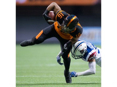 B.C. Lions' Bryan Burnham, left, is hit by Montreal Alouettes' Greg Henderson after making a reception during the first half of a CFL football game in Vancouver, B.C., on Friday September 9, 2016.