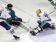Vancouver Canucks goalie Michael Garteig, right, deflects a shot from San Jose Sharks' Ryan Carpenter during the third period of an NHL preseason hockey game Tuesday, Sept. 27, 2016, in San Jose, Calif.