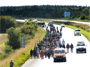 Migrants, mainly from Syria and Iraq, walk along the E45 freeway from the Danish-German border, heading north to try to get to Sweden. Now Sweden has decided to halt its open-arms policy for refugees.