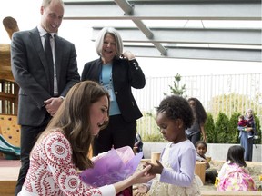 Kate, the Duchess of Cambridge receives flowers from a girl as her husband, William, the Duke of Cambridge, looks on during a visit to the Immigration Services Society in Vancouver on Sunday. — The Canadian Press