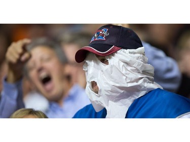 A Montreal Alouettes hides his face with a plastic bag while watching the team play the B.C. Lions during the first half of a CFL football game in Vancouver, B.C., on Friday September 9, 2016.