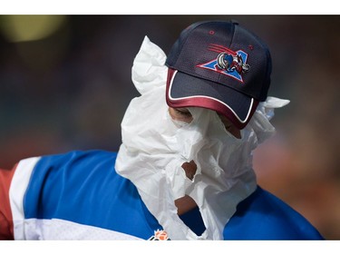 A Montreal Alouettes hides his face with a plastic bag while watching the team play the B.C. Lions during the first half of a CFL football game in Vancouver, B.C., on Friday September 9, 2016.