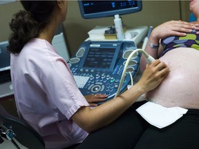 A doctor conducts an ultrasound scan to a maternity ward patient.