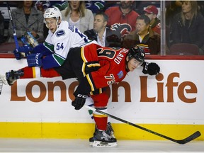 Vancouver Canucks' Guillaume Brisebois, left, is checked by Calgary Flames' Micheal Ferland during first period pre-season NHL hockey action in Calgary, Friday, Sept. 30, 2016.THE CANADIAN PRESS/Jeff McIntosh ORG XMIT: JMC101