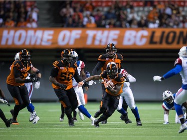 B.C. Lions' Jeremiah Johnson, centre, carries the ball against the Montreal Alouettes during the second half of a CFL football game in Vancouver, B.C., on Friday September 9, 2016.