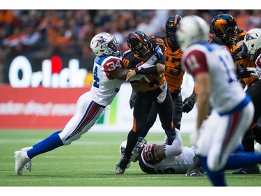 B.C. Lions' quarterback Jonathon Jennings, second left, is sacked by Montreal Alouettes' Kyries Hebert, left, as Gabriel Knapton, bottom, grabs his leg during the first half of a CFL football game in Vancouver, B.C., on Friday September 9, 2016.