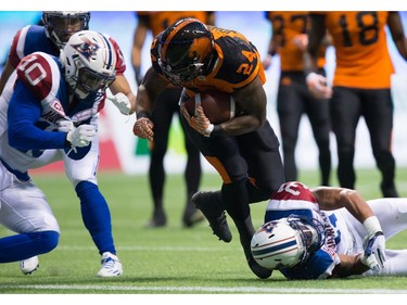 B.C. Lions' Jeremiah Johnson, centre, scores a touchdown as Montreal Alouettes' Marc-Olivier Brouillette, left, and Winston Venable defend during the first half of a CFL football game in Vancouver, B.C., on Friday September 9, 2016.