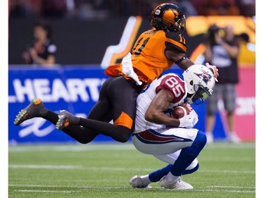 Montreal Alouettes' B.J. Cunningham, right, makes a reception under B.C. Lions' Mike Edem during the first half of a CFL football game in Vancouver, B.C., on Friday September 9, 2016.