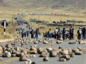 In this 2011 file photo, protesters block the road in Yorohoco, near the Peru-Bolivia border, during a protest against the Bear Creek Mining Company mining project.