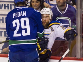 Andrey Pedan checks the Blues' Alex Pietrangelo.