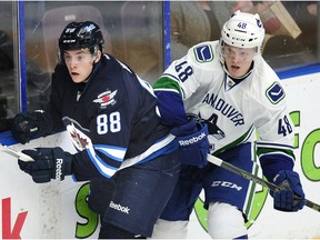 Vancouver Canucks' Olli Juolevi (78) on the boards with  Winnipeg Jets' Antoine Waked (88) during first period 2016 NHL Young Stars Classic action at the South Okanagan Events Centre in Penticton earlier this month.