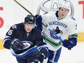 Vancouver Canucks' Troy Stecher chases the  Winnipeg Jets' Jikky Lodge (45).