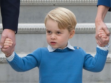 Prince George, centre, holds the hands of his parents The Duke and Duchess of Cambridge after arriving in Victoria, B.C., on Saturday, September 24, 2016.