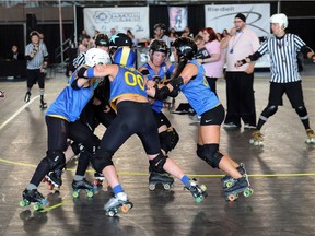 Members of the Stockholm All Stars battle with the Lake Effect Furies during Division 1 Playoffs of the Women's Flat Track Roller Derby International Championships at the Richmond Olympic Oval.