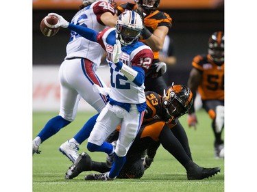 Montreal Alouettes' quarterback Rakeem Cato, left, is sacked by B.C. Lions' Alex Bazzie during the second half of a CFL football game in Vancouver, B.C., on Friday September 9, 2016.