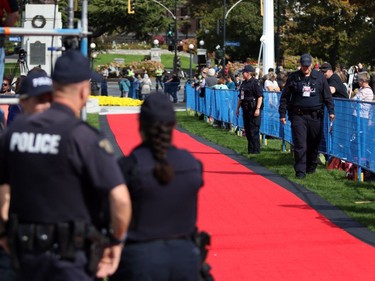 RCMP officers conduct a sweep as hundreds of people wait to greet the Duke and Duchess of Cambridge before their arrival at the B.C. Legislature in Victoria, B.C., Saturday, Sept 24, 2016.