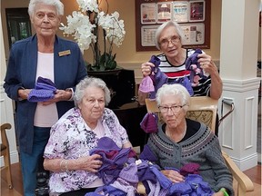 Imperial Place residents, clockwise from back left, Myrna Switaiski, Martha Schnider, Joan Burwash, and Margarete Bausman hold the caps made for the Click for Babies campaign.