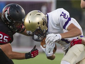 The Vancouver College Fighting Irish's Bobby Singh, right, lowers the boom on Terry Fox Ravens defender Matt Shuen during a B.C. high school game at Perry stadium in Coquitlam earlier this month.