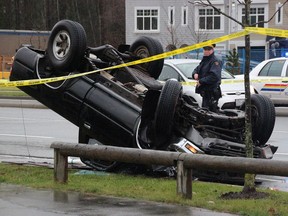 Surrey RCMP and firefighters attend to an overturned Toyota pickup truck that had been involved in a series of carjackings and crashes in the area of 68th Avenue and Fraser Highway on Dec. 23, 2014. A suspect in the crime spree has been found guilty of seven offences.