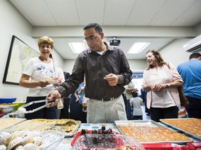 Bassam Sua'Ifan is a volunteer who is serving food to guests at the Refugee and Immigrant Welcome Centre in Surrey, B.C.