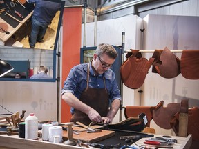 The Herme`s at Work exhibition provides vistors with a look into the various 'métiers' of the French fashion house's artisans such as saddlemaking, leather working for handbags, silk printing and more. A man works on a saddle in this handout image.