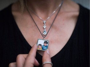 FILE - Friday marks the one-year anniversary of the death of Alan Kurdi, a two-year-old Syrian boy immortalized in a chilling photograph that captured the price all too often paid by those struggling to escape a years-long civil war. Tima Kurdi wears a photograph of her late nephews Alan, left, and Ghalib Kurdi on a necklace while posing for a photo at her home in Coquitlam, B.C., in an August 22, 2016, file photo.