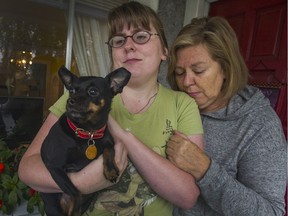 Mia Johnson with her daughter Laurel and surviving dog Mary in Vancouver, B.C., October 30, 2014. Mia's miniature pinscher Yuri a service dog for her daughter, who has autism and anxiety was killed while walking on-leash on Saturday. It was attacked by a muzzled Staffordshire. The muzzle came off during the attack and Yuri was disembowelled.