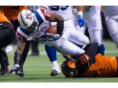 Montreal Alouettes' Tyrell Sutton, left, is stopped by B.C. Lions' Mic'hael Brooks during the first half of a CFL football game in Vancouver, B.C., on Friday September 9, 2016.