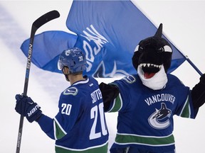 Vancouver Canucks centre Brandon Sutter (20) fist bumps Canucks mascot "Fin" after his game winning goal against the Carolina Hurricanes in overtime during NHL hockey action in Vancouver, B.C., on Sunday, Oct. 16, 2016. THE CANADIAN PRESS/Jonathan Hayward ORG XMIT: JOHV122