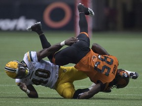 Edmonton Eskimos linebacker Deon Lacey (40) tackles BC Lions slotback Shawn Gore.