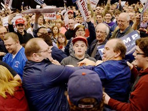 A protester, center left, and a Trump supporter, center right, scuffle during a rally for Republican presidential candidate Donald Trump Saturday, March, 12, 2016, held at the I-X Arena in Cleveland, Ohio.