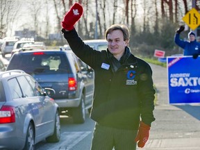 Then-federal Conservative MP Andrew Saxton waves to motorists at the north end of the Ironworkers Memorial Bridge in April 2011, during his successful re-election campaign in the riding of North Vancouver. Saxton will announce Tuesday that he’s running for the federal party’s leadership.