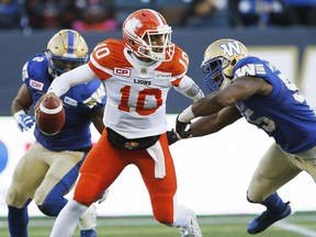 B.C. Lions quarterback Jonathon Jennings (10) scrambles away from Winnipeg Blue Bombers' Khalil Bass (2) and Jamaal Westerman (55) during the first half of CFL action in Winnipeg Saturday, October 8, 2016.