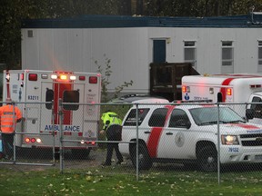 Emergency personnel work at the scene near Clayton Heights Secondary in Surrey where a 15-year-old boy was killed Friday by a falling tree.