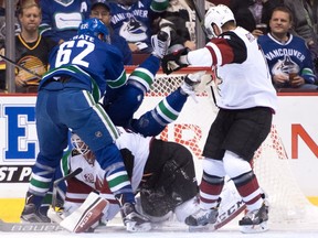 Vancouver Canucks' Tuomo Ruutu, back centre, of Finland, falls over Arizona Coyotes' goalie Louis Domingue as he covers up the puck while teammate Brad Richardson, right, and Canucks' Joseph Labate watch during the first period of a pre-season NHL hockey game in Vancouver, B.C., on Monday October 3, 2016.