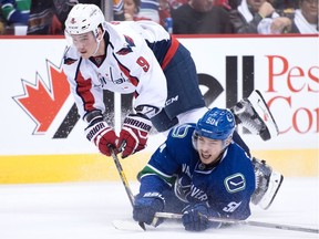 Washington Capitals' Dmitry Orlov, back, of Russia, and Vancouver Canucks' Brendan Gaunce collide during the first period of an NHL hockey game in Vancouver, B.C., on Saturday October 29, 2016.