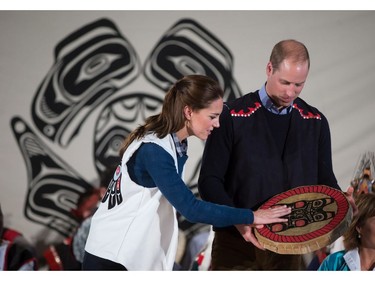 Wearing First Nations vests they were given, Britain's Prince William, the Duke of Cambridge, and Kate, the Duchess of Cambridge, hold a traditional drum they were presented during a welcoming ceremony at the Heiltsuk First Nation in the remote community of Bella Bella, B.C., on Monday September 26, 2016.
