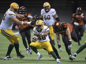 Edmonton Eskimos wide receiver Bryant Mitchell (80) tries to run with the ball during the second half of CFL football action against the B.C. Lions, in Vancouver on Saturday, Oct. 22, 2016.